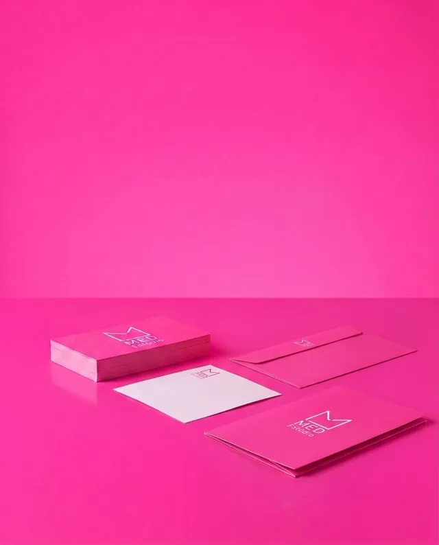 Papelaria corporativa: exemplos em rosa com logo da Med Estúdio