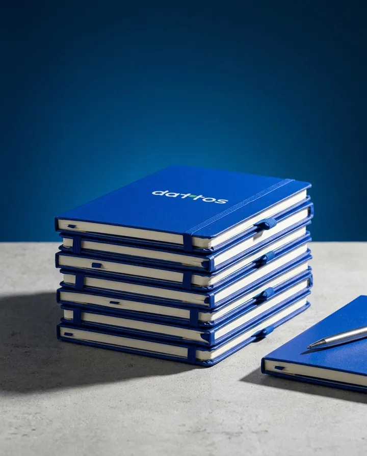 Pila de cuadernos azules con el logo de Dattos